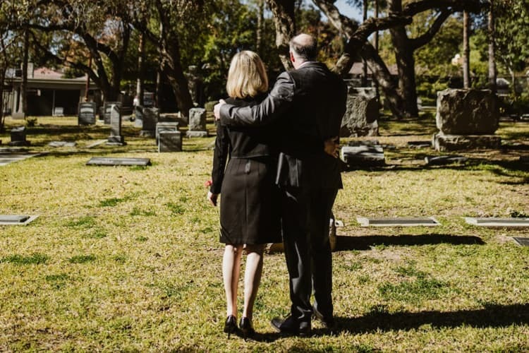 As this couple standing in a graveyard know bereavement is difficult.